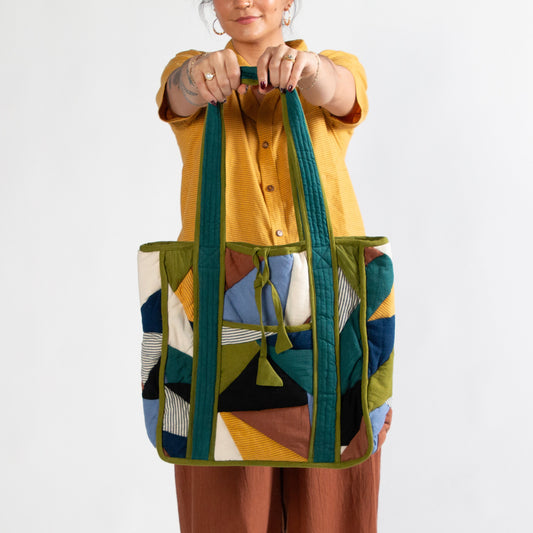 Person holding a colorful patterned bag against a white background
