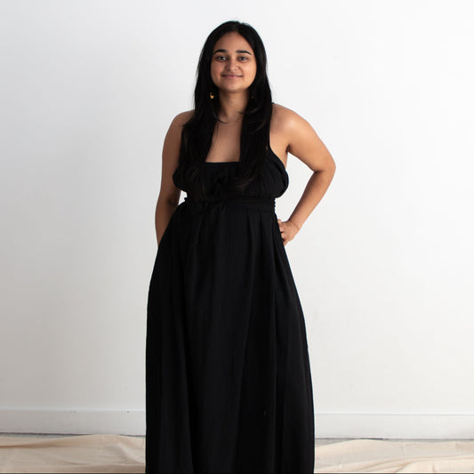 Woman wearing a black dress standing against a white background