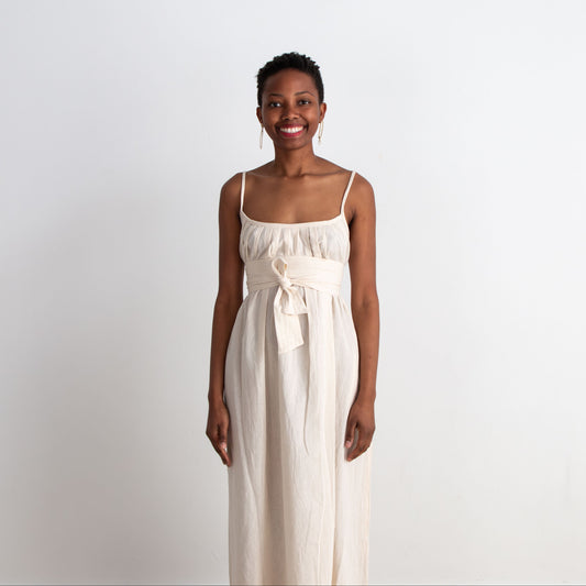 Woman wearing a white dress against a plain background