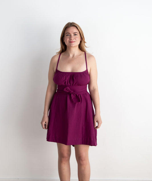 Woman wearing a purple dress against a white background