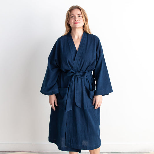 Woman wearing a navy blue robe against a white background