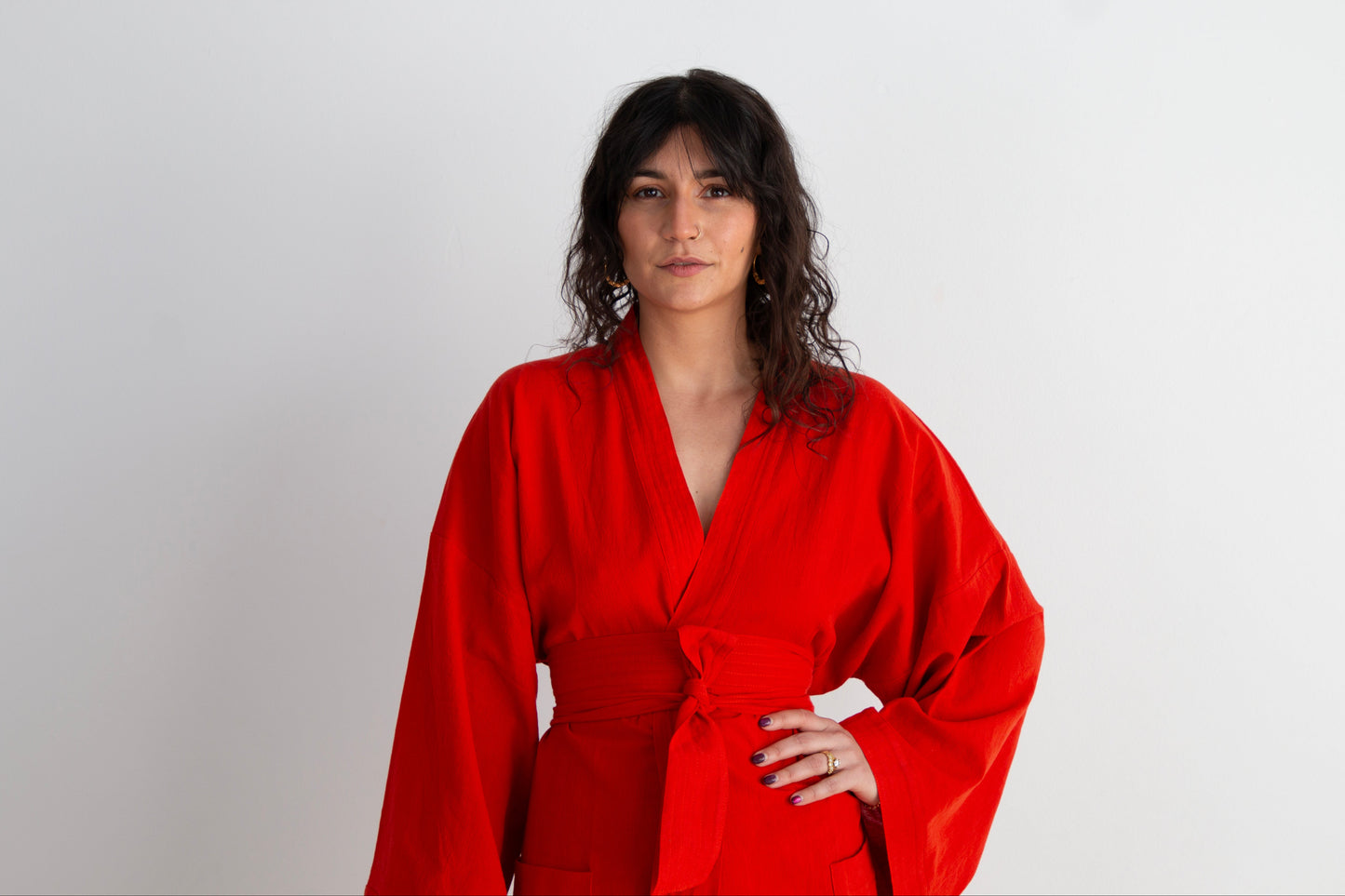 Woman wearing a red robe against a white background