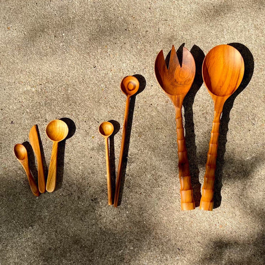 A set of hand-carved wooden utensils, including spoons, a fork, and a spoon