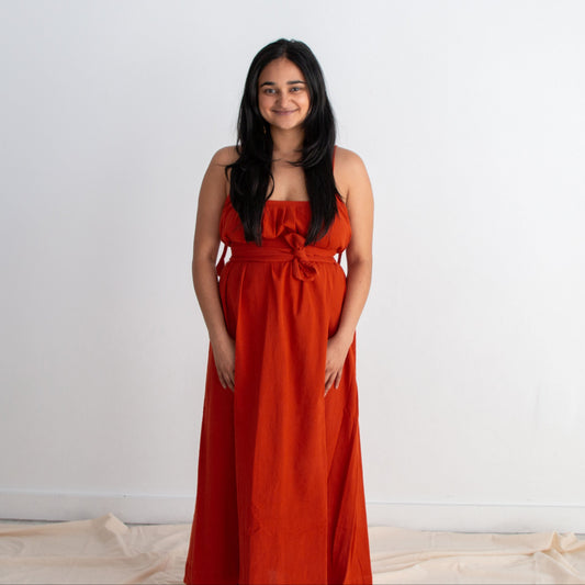 Woman wearing a red dress standing against a white background