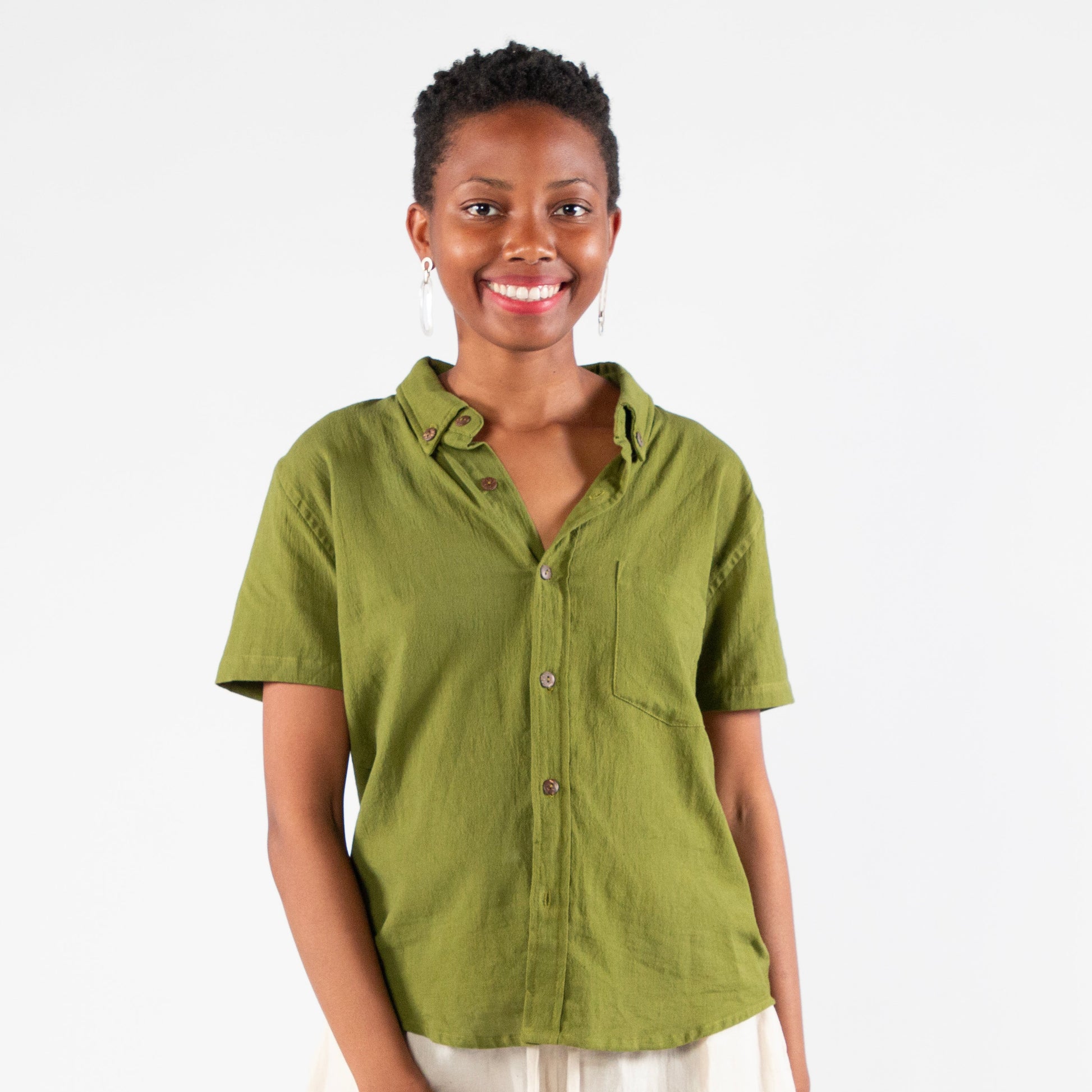 Woman wearing a green shirt and white pants on a white background