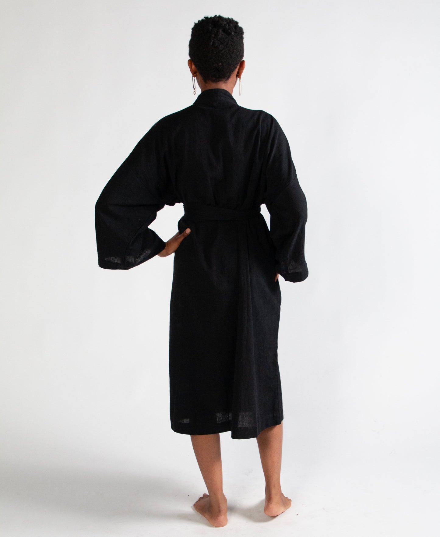 Person wearing a black robe from behind on a white background