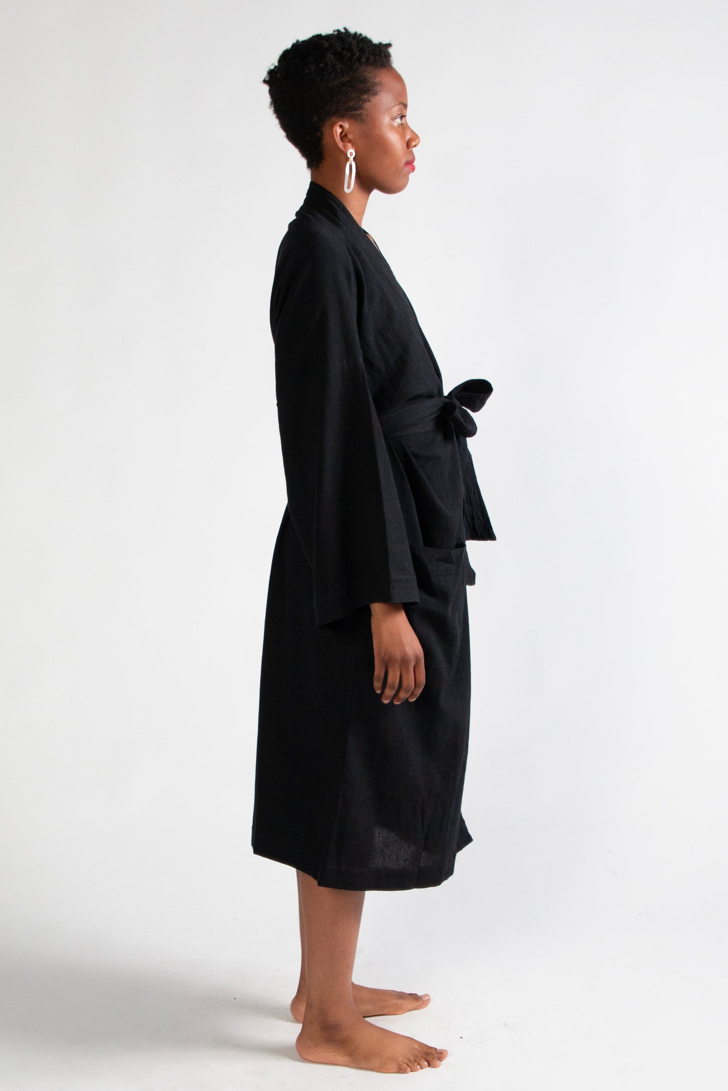 Person wearing a black robe standing against a white background
