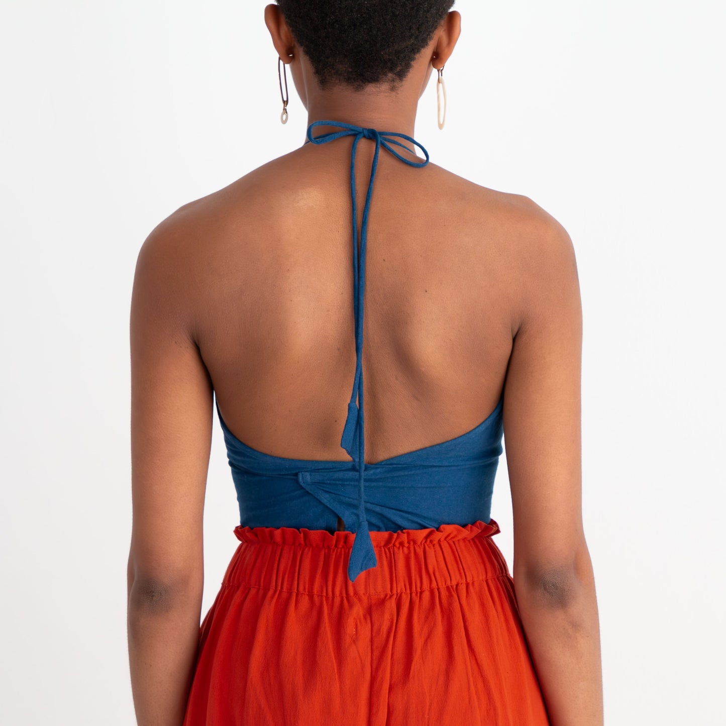Woman wearing a blue top and red dress on a white background