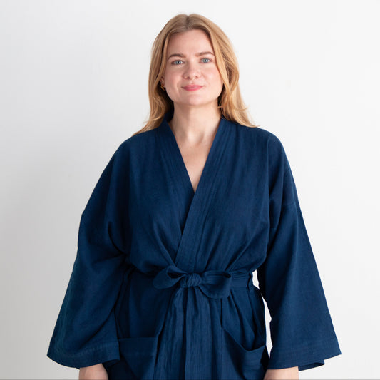 Woman wearing a navy blue robe against a white background