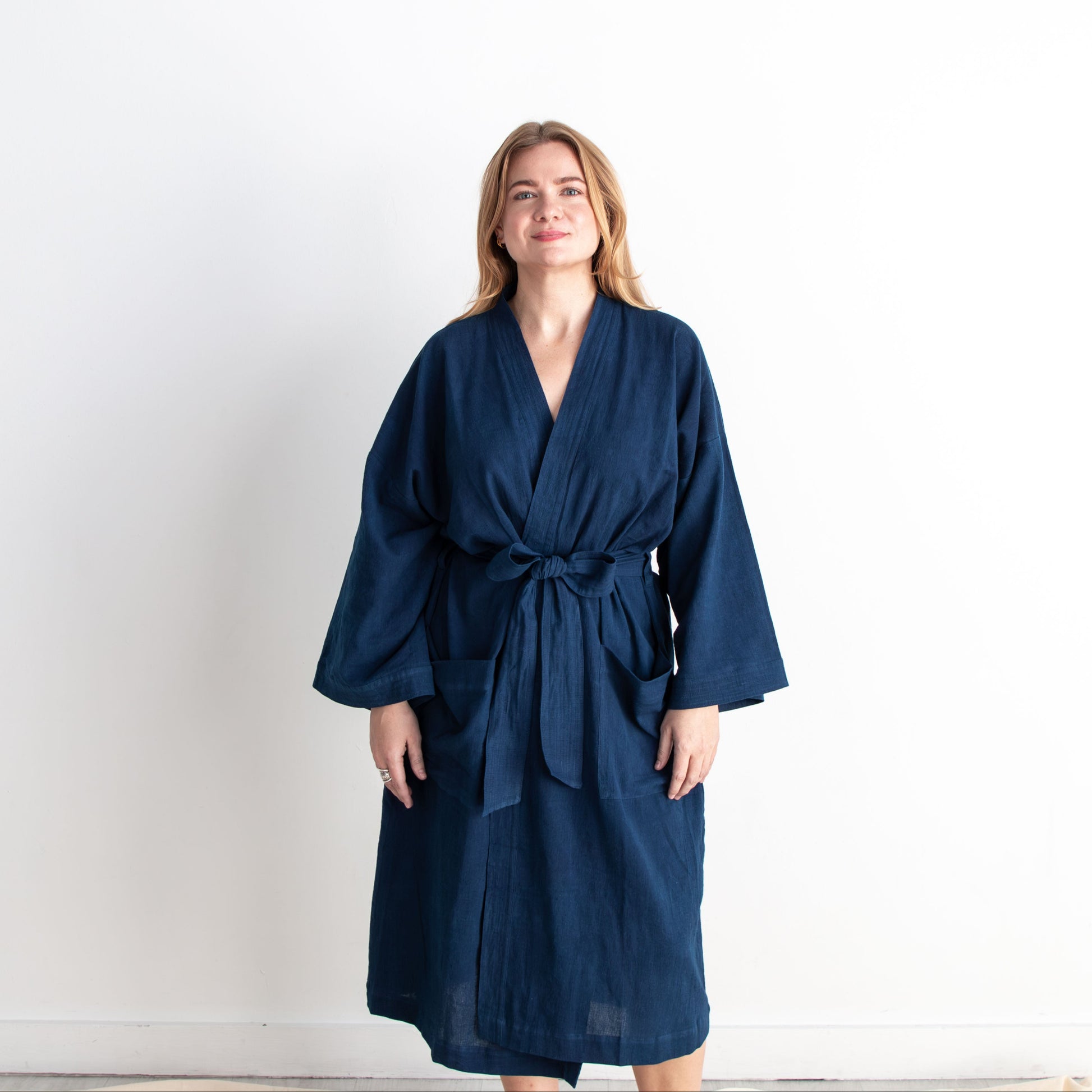 Woman wearing a navy blue robe against a white background