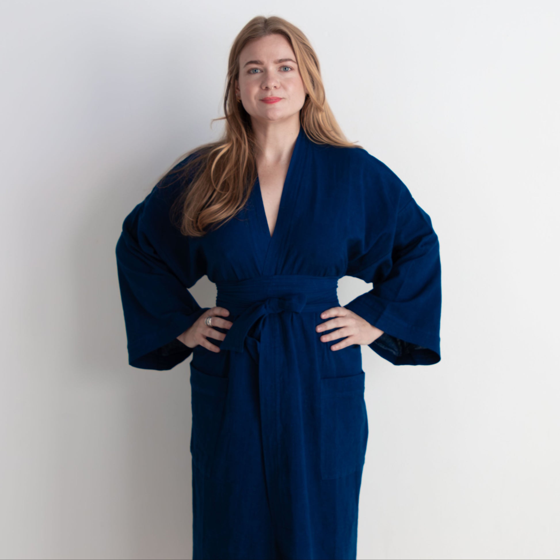 Woman wearing a blue wrap dress against a white background
