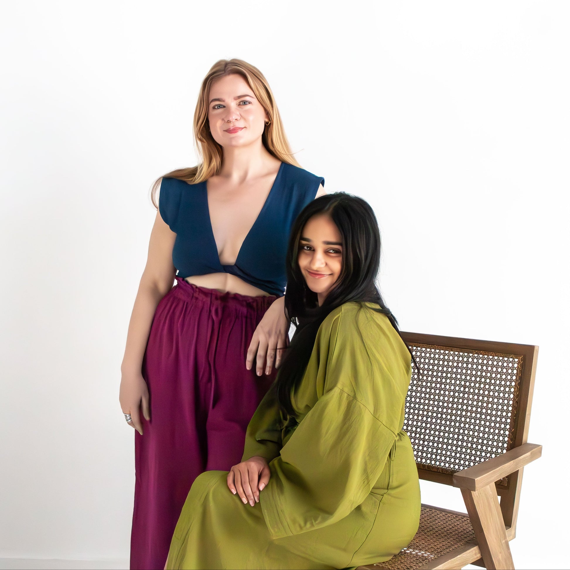 Two women posing together on a white background