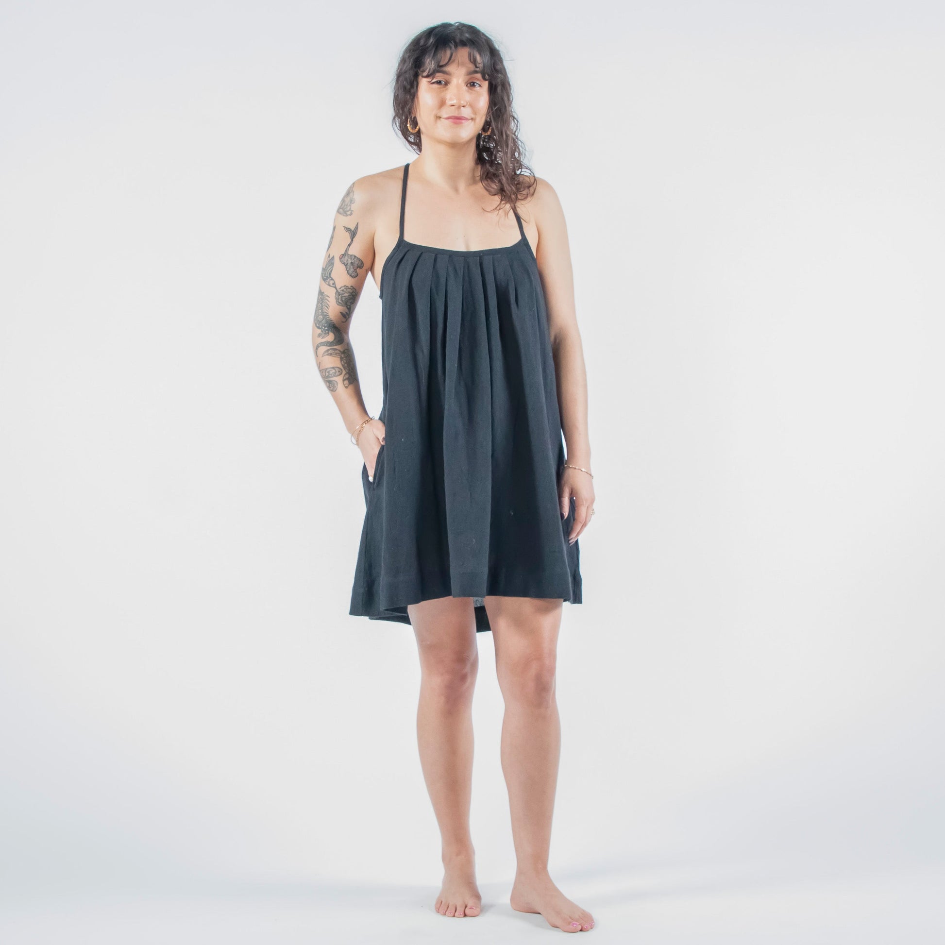 Woman wearing a black dress standing on a white floor 