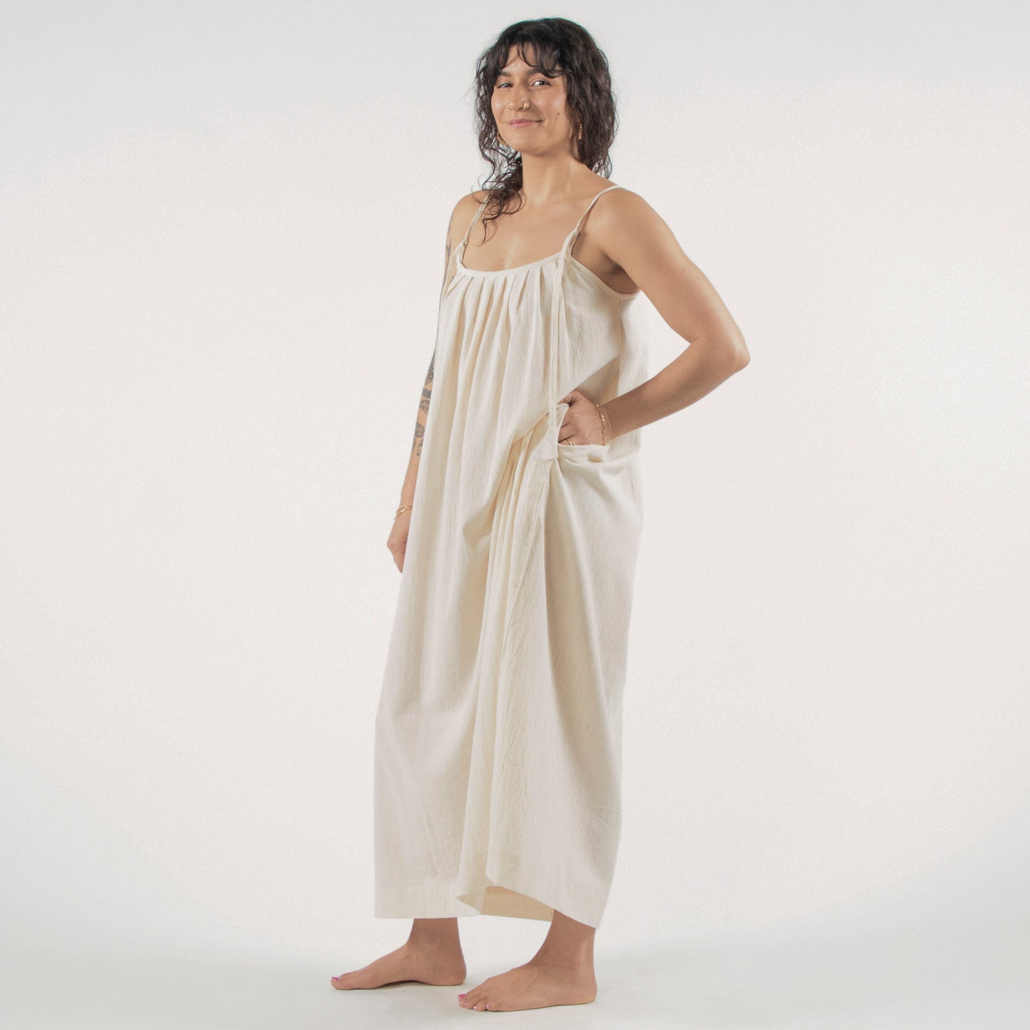 Woman wearing a white dress standing on a white background 
