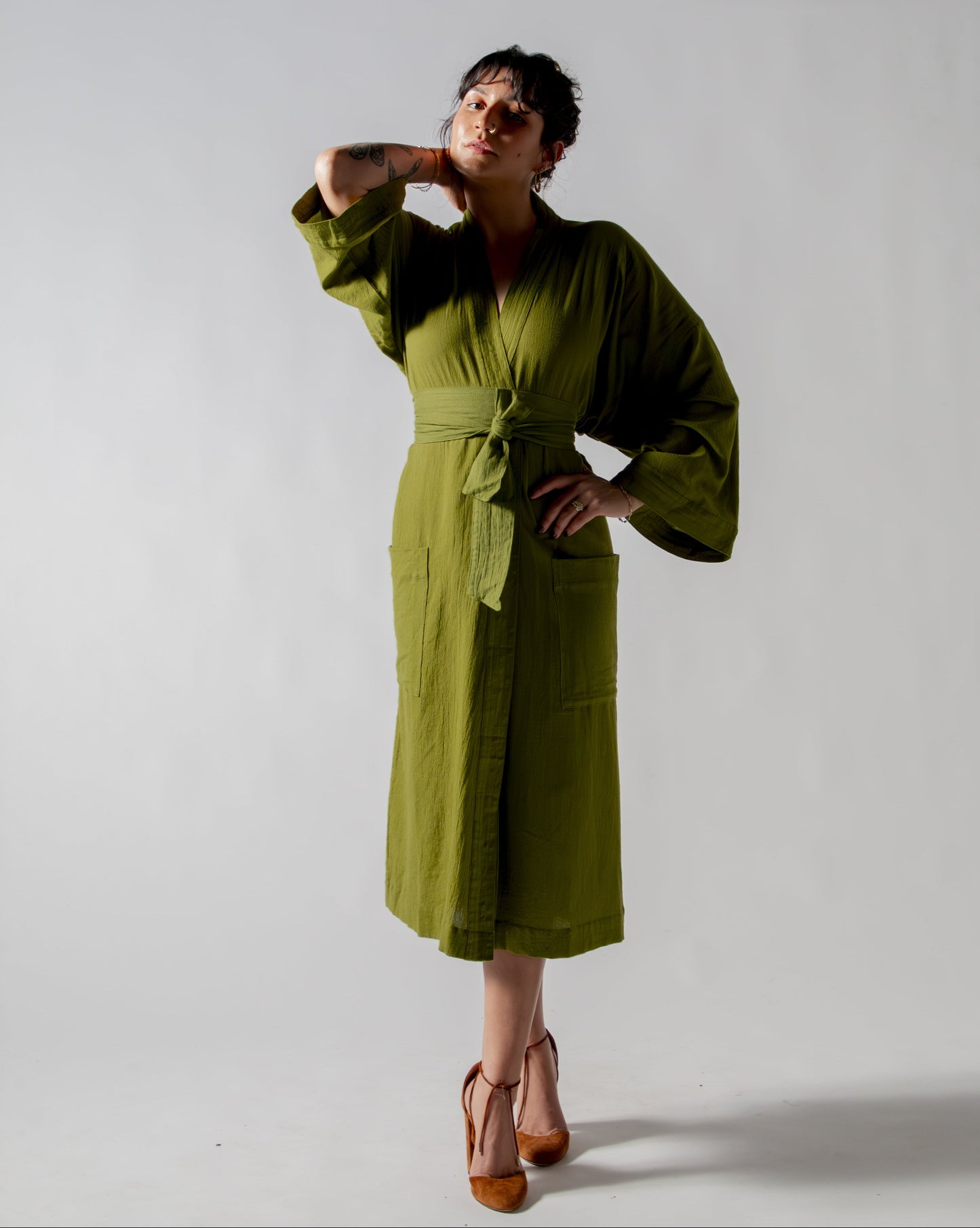 Woman wearing a green dress against a plain background