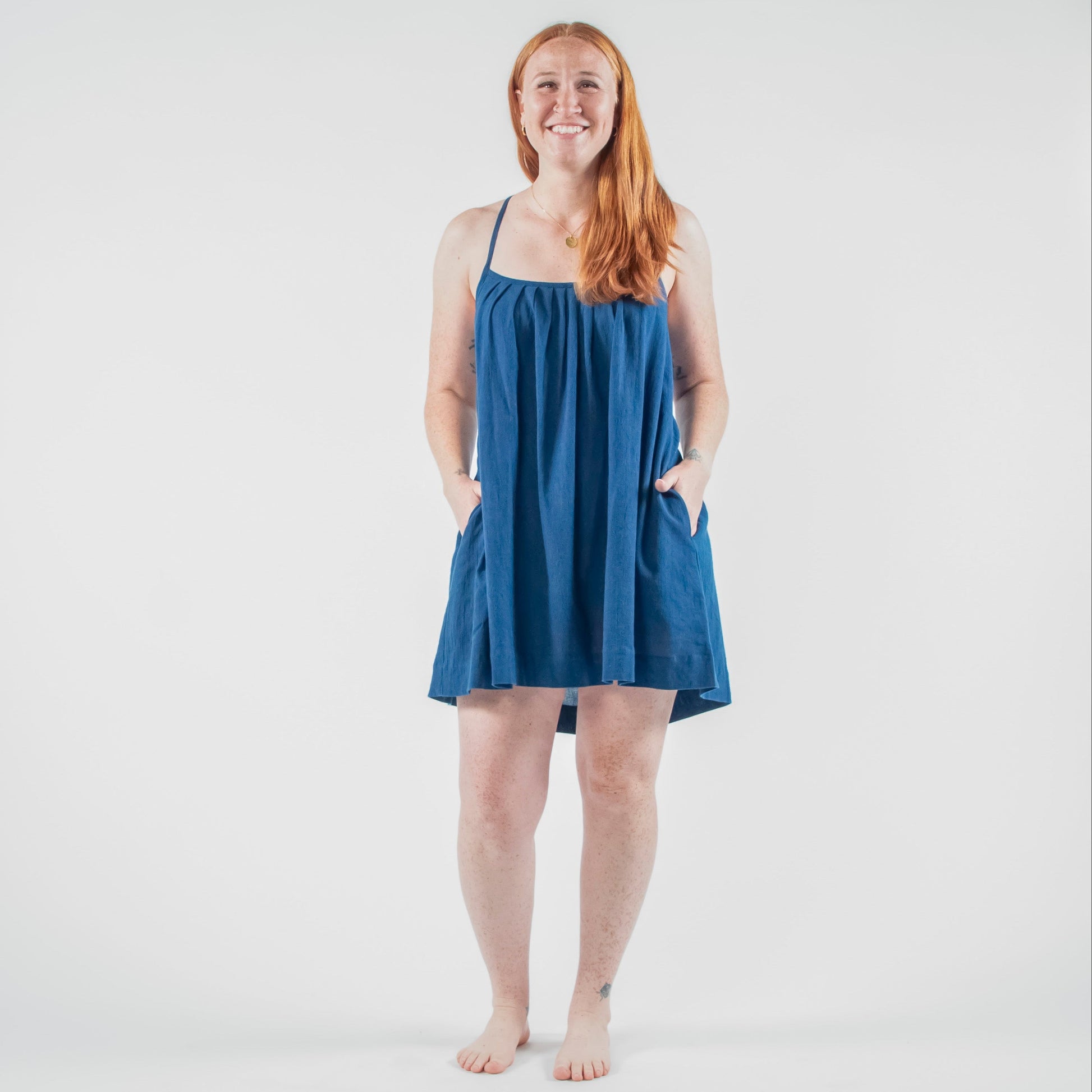 Woman wearing a blue dress standing on a white background 