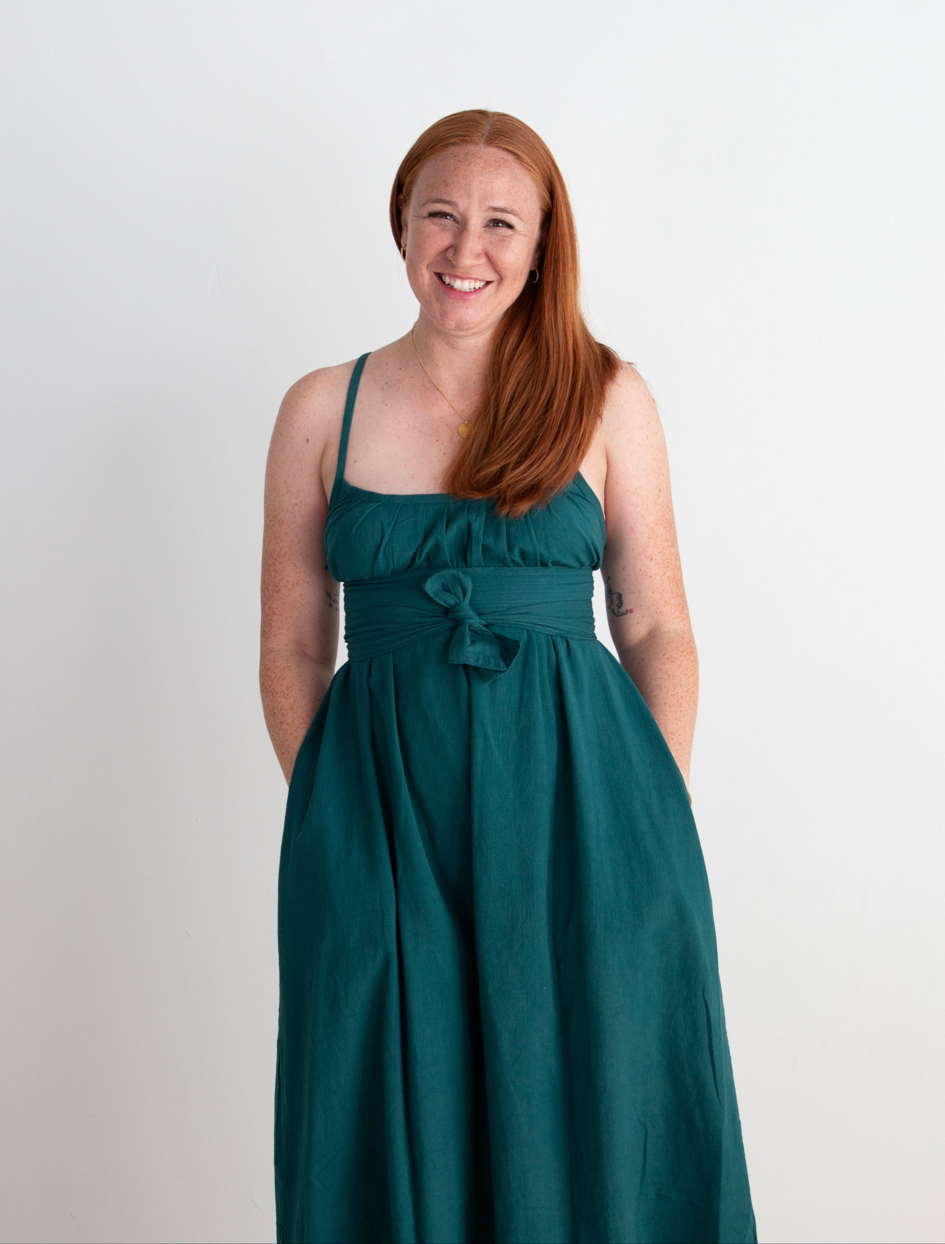 Woman wearing a teal dress against a white background