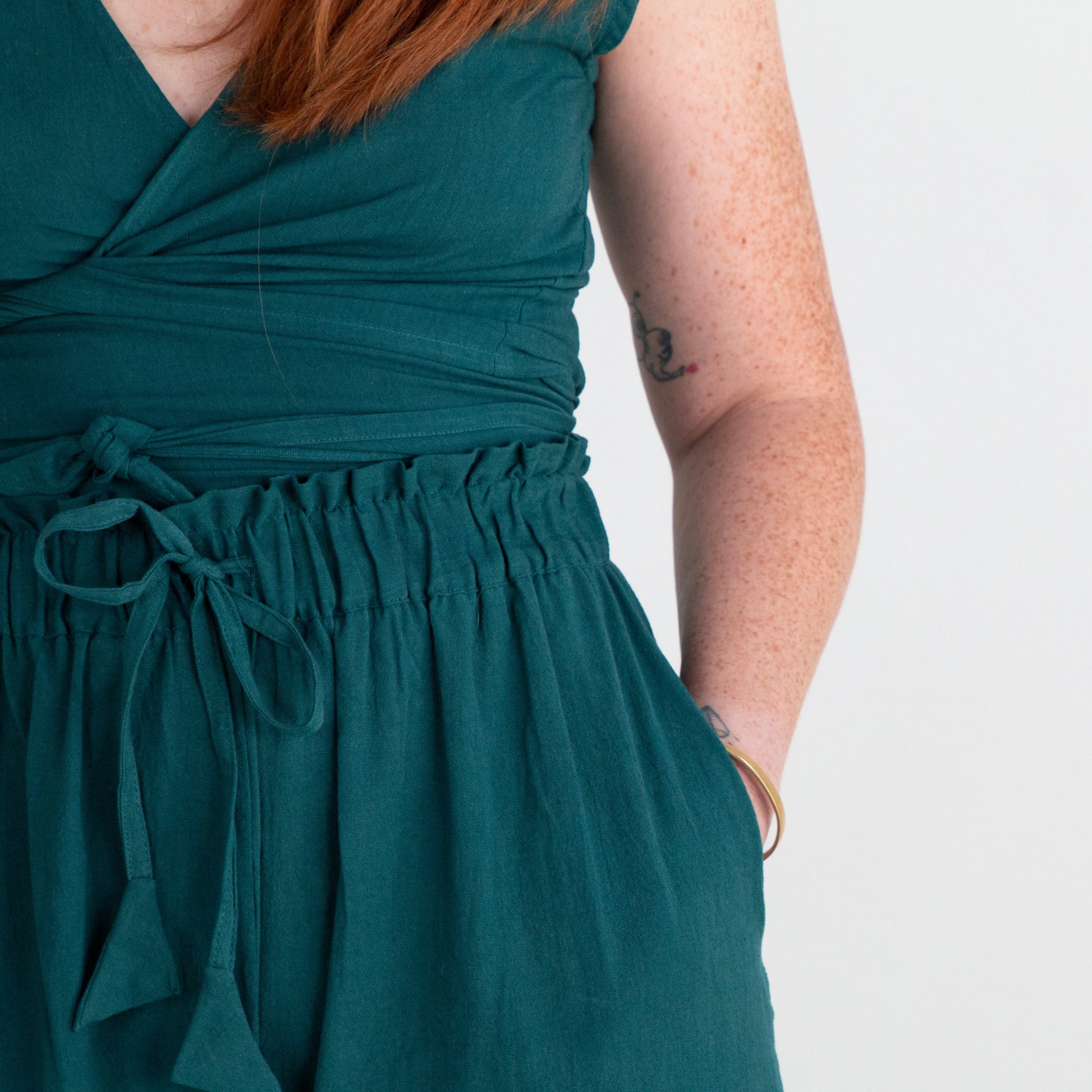 Teal top worn by a person on a plain background