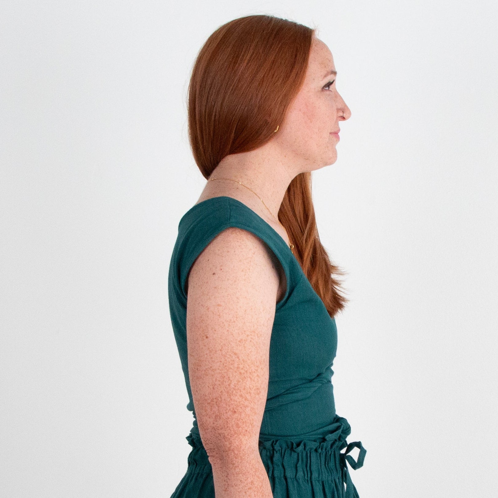 Teal top worn by a person on a plain background