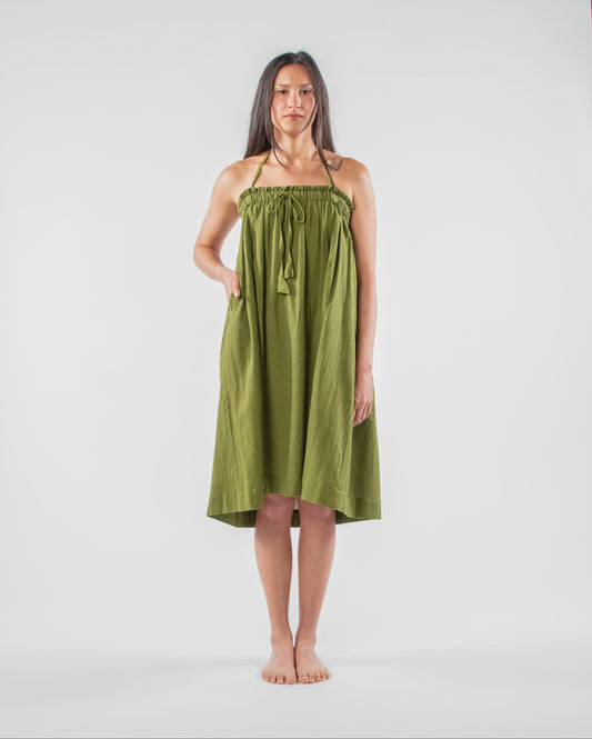 Woman wearing a green dress standing on a white background 