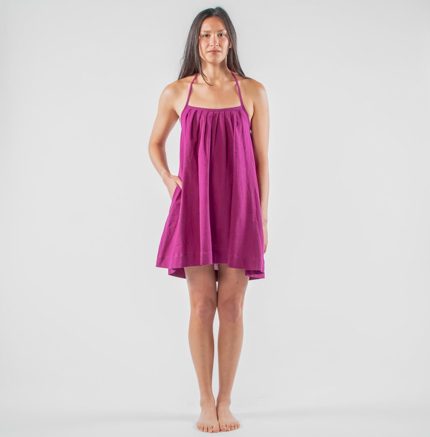 Woman wearing a purple dress standing in a studio setting 