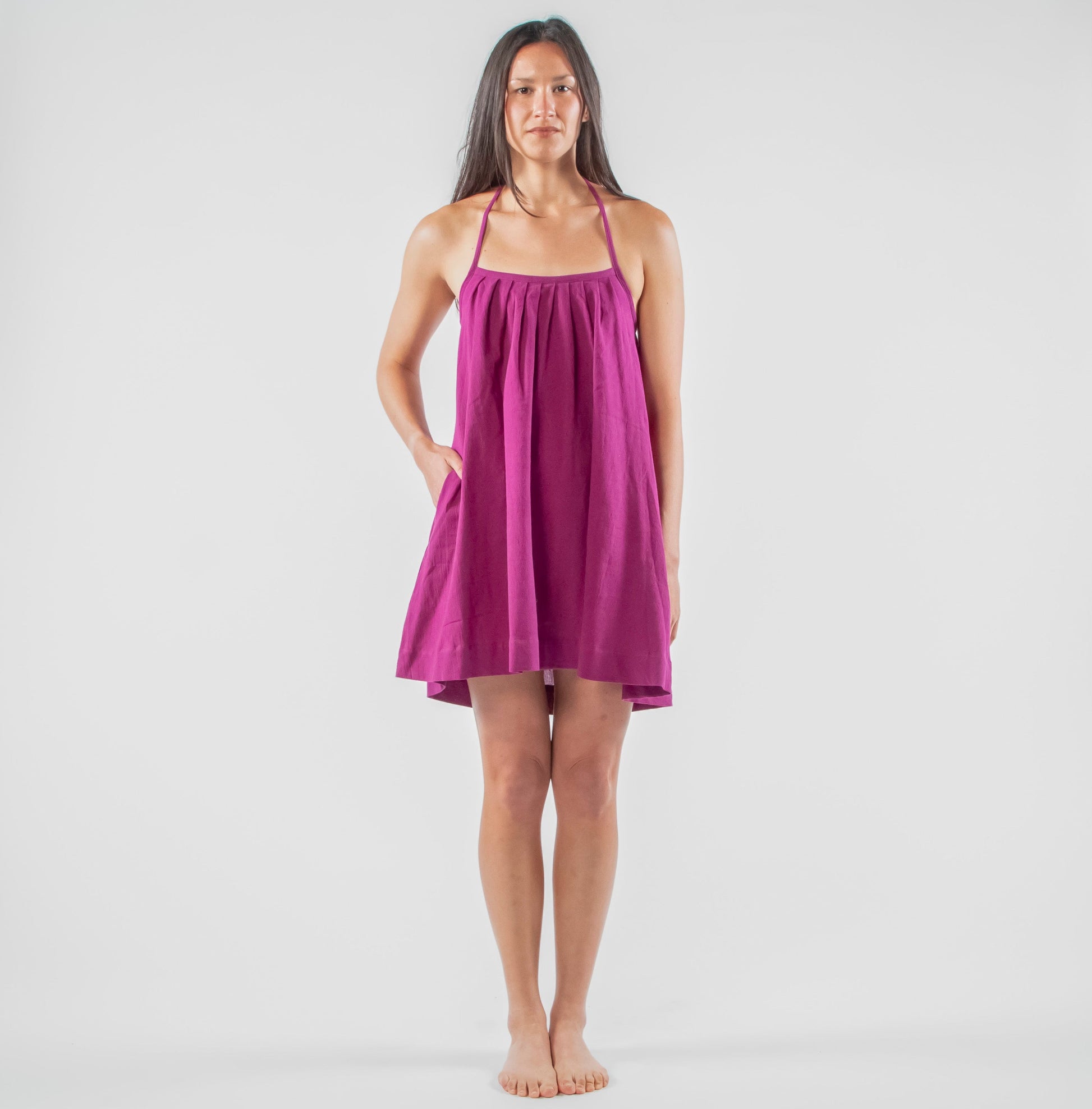 Woman wearing a purple dress standing in a studio setting 