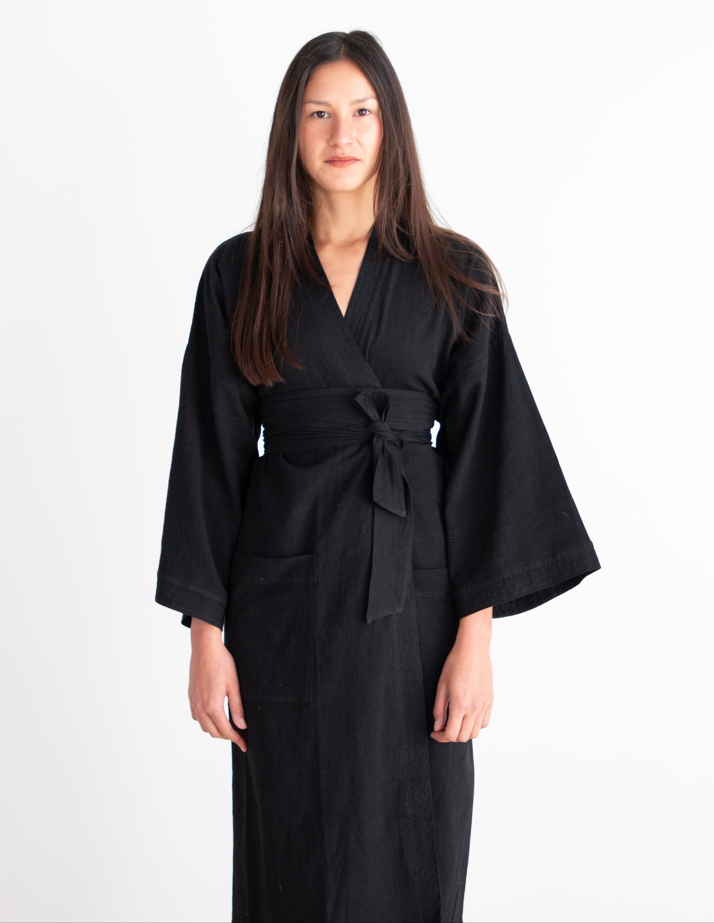 Woman wearing a black robe against a white background