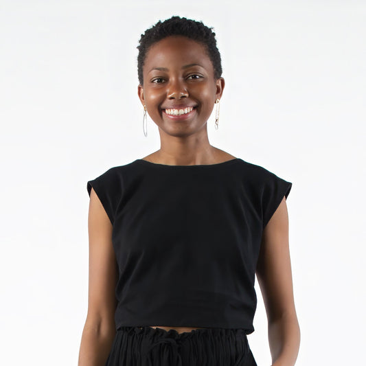 Person wearing a black outfit standing on a white background